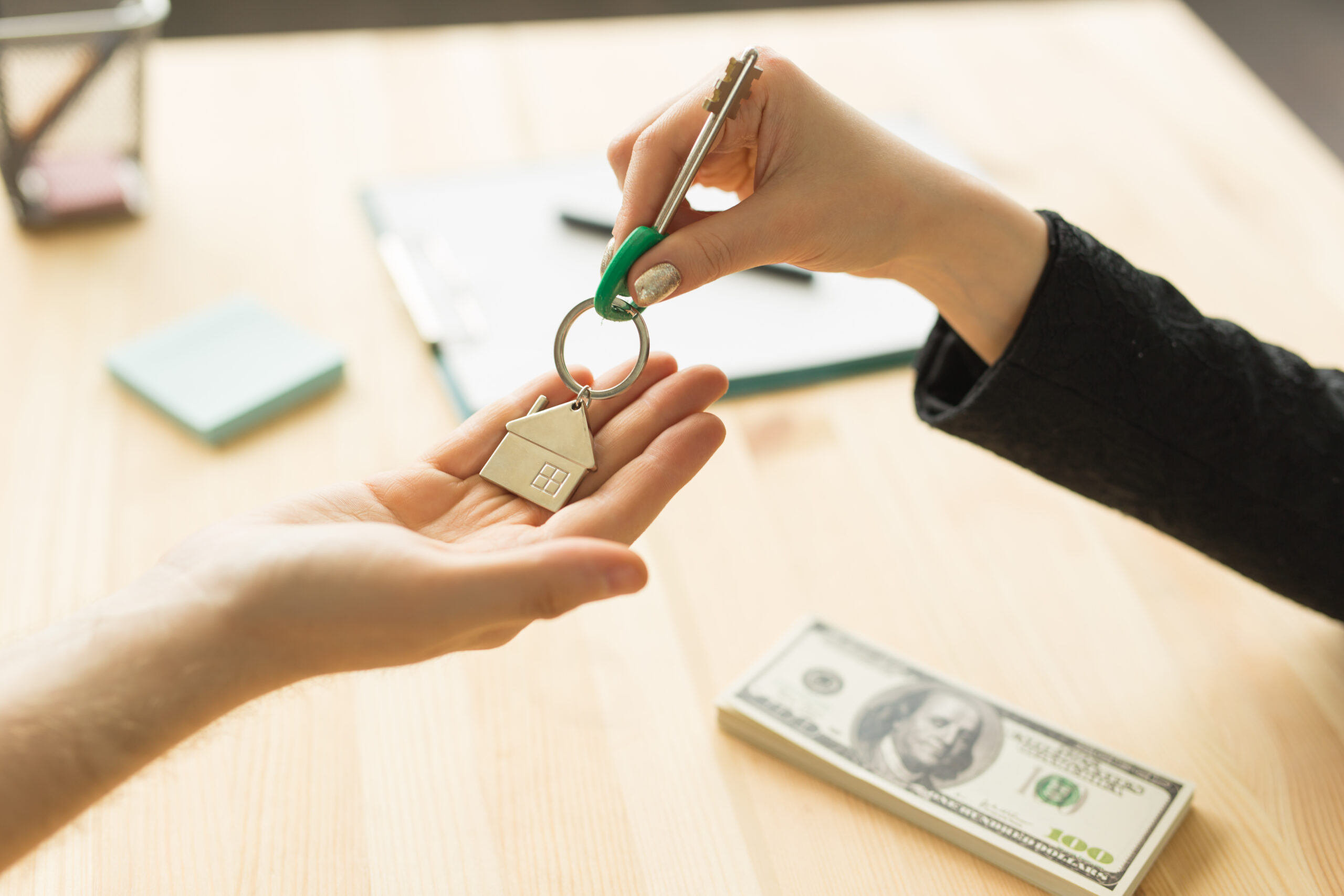 Business, realtor and real estate concept - Hand-to-hand key from new home.